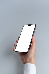 Poster - Hand holds a smartphone with blank, isolated screen against a grey background. Isolated screen for mockup, app or web page presentation