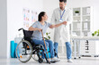 © Pixel-Shot - Male physiotherapist helping young woman to stand up in rehabilitation center
