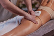 Anti-cellulite massage in the spa salon. The masseur massages the buttocks, thigh and legs. Relaxing treatment. Slimming and body shaping. Healthy body and skin. Self love care.