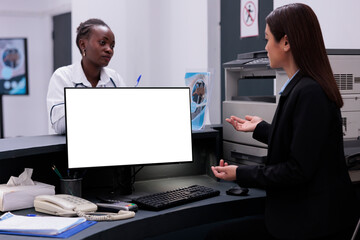 Wall Mural - Reception worker manages patient records and schedules appointments typing medical information on computer with white isolated screen. Hospital staff working at health care treatment for patients