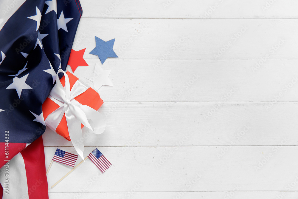 Gift box with USA flags and stars on white wooden background. American Independence Day