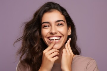 Poster - Headshot portrait photography of a grinning girl in her 20s placing the hand over the mouth in a laughter gesture against a soft lavender background. With generative AI technology