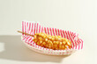 Delicious Crunchy Korean Style Chunky Potato Corn Dogs with Batter and Fried Potatoes. Isolated on Cream Background