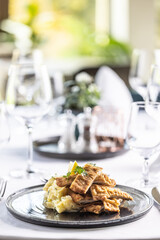 Wall Mural - Viennese schnitzel cut into strips and styled on a potato salad in the restaurant