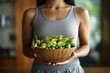 © sirisakboakaew - Healthy salad bowls held by Asian women in gym clothes to promote good health and wellness at home.;Generated with AI