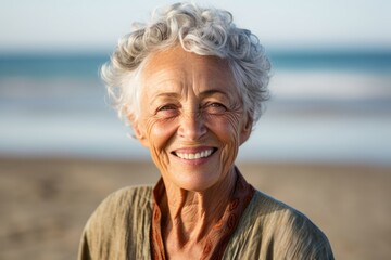 Wall Mural - Studio portrait photography of a grinning old woman wearing a sophisticated blouse against a serene beach background. With generative AI technology