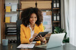 © laddawan - African Woman freelancer is working her job on computer tablet and laptop Doing accounting analysis report real estate investment data, Financial