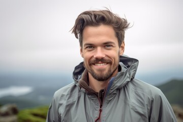 Poster - Headshot portrait photography of a grinning boy in his 30s wearing a lightweight windbreaker against a scenic mountain overlook background. With generative AI technology