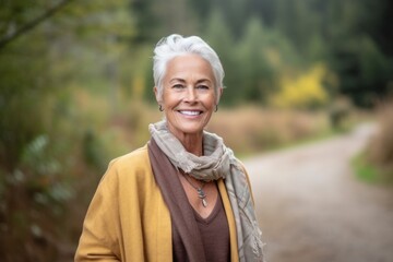 Wall Mural - Environmental portrait photography of a grinning mature woman wearing a chic cardigan against a serene nature trail background. With generative AI technology