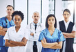 © Diane Munro/peopleimages.com - Medical, crossed arms and portrait of group of doctors standing in the hallway with confidence. Serious, diversity and team of professional healthcare workers in a medicare clinic or hospital.