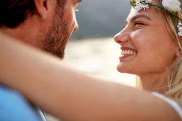 Wall Mural - Close up portrait shot of joyful bride with big smile looking at her husband. Couple by seaside. Wedding, travel, honeymoon, love concept