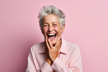 Wall Mural - Medium shot portrait photography of a grinning mature woman covering his mouth against a pastel or soft colors background. With generative AI technology