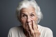 © Markus Schröder - Close-up portrait photography of a satisfied old woman making a gesture of silence with his finger on his lips. With generative AI technology
