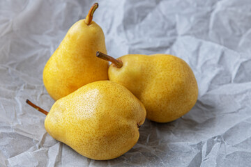 Wall Mural - sweet ripe pears on white parchment close up