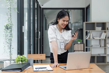 Sticker - Beautiful woman in the office, happy and smiling business woman uses internet phone, female worker reads message and browses internet pages inside office building