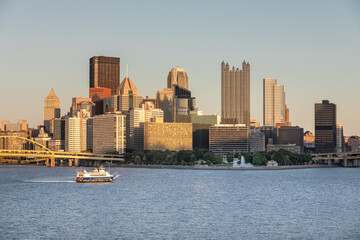 Canvas Print - Cityscape of Pittsburgh, Pennsylvania. Allegheny and Monongahela Rivers in Background. Ohio River. Pittsburgh Downtown With Skyscrapers and Beautiful Sunset Sky. Ferry in Roreground