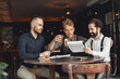 © prostooleh - Three bearded men are drinking whiskey and talking.