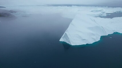 Poster - Elevated view flying between the iceberg peaks and large icebergs floating shrouded in fog at Ilulissat Icefjord, Arctic Ocean, Greenland Ice Sheet, Icecap, Ilulissat, Climate Change