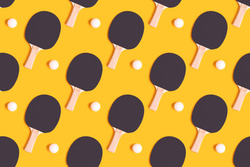 Wall Mural - Pattern made of tennis racket and white ball on a yellow background. Ping pong creative composition.