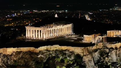 Wall Mural - Closeup aerial night view of the illuminated Parthenon Temple at the Acropolis of Athens, Greece, with the city skyline in the background