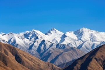 Wall Mural - majestic mountain range, with snowcapped peaks and clear blue skies, created with generative ai