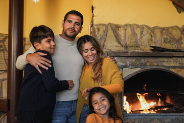 Wall Mural - Happy latin family having tender moment together in front of fireplace