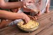 © dvulikaia - Close up female hands cooking pie. Little girl helps her mother to cook sweet cheesecake.