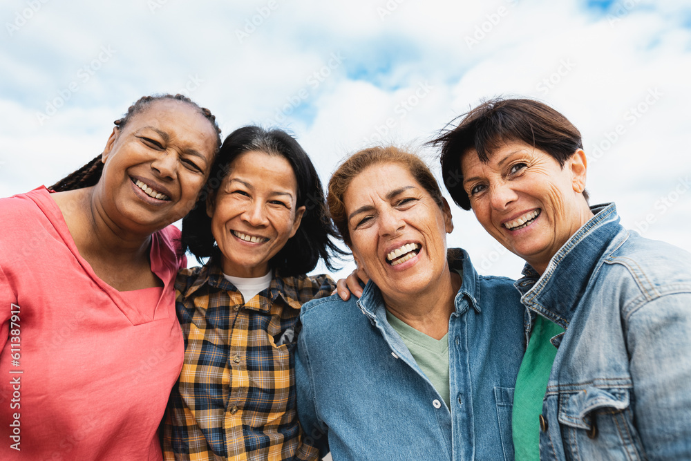 Happy multiracial senior women having fun smiling into the camera at ...