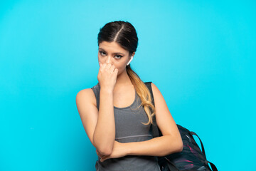 Wall Mural - Young sport Russian girl with sport bag isolated on blue background having doubts