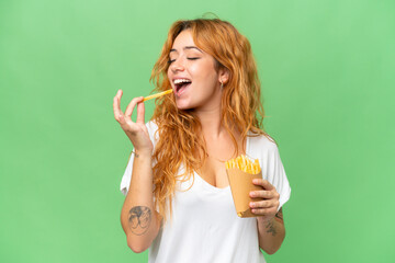 Wall Mural - young caucasian woman holding fried chips isolated on green screen chroma key background