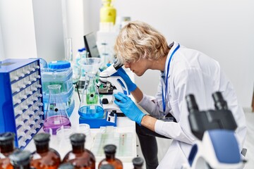 Poster - Young blond man scientist using microscope at laboratory