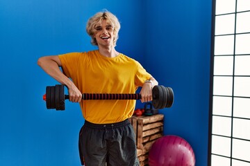 Sticker - Young blond man smiling confident using weight training at sport center