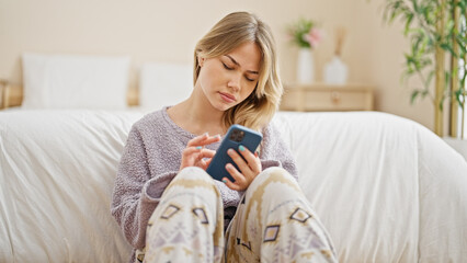 Poster - Young blonde woman using smartphone sitting on floor at bedroom