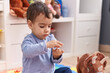 © Krakenimages.com - Adorable hispanic boy sitting on floor with relaxed expression at kindergarten