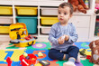 © Krakenimages.com - Adorable hispanic boy playing supermarket game sitting on floor at kindergarten