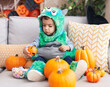 © Krakenimages.com - Adorable hispanic boy having halloween party holding pumpkin basket at home