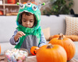 © Krakenimages.com - Adorable hispanic boy having halloween party holding sweets at home
