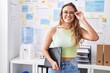 © Krakenimages.com - Young beautiful hispanic woman business worker smiling confident holding binder at office