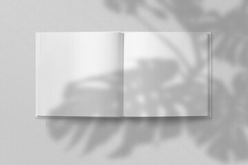 Realistic top view cover and opened portrait A4 or A5 magazine or brochure booklet for stationery and branding. Mockup template isolated light grey background and leaf shadow overlay. 3D rendering.