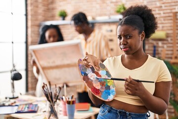 Sticker - Young black painter woman at art studio holding palette skeptic and nervous, frowning upset because of problem. negative person.