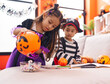 © Krakenimages.com - Adorable boy and girl having halloween party holding candies at home