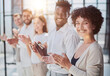 © Katsiaryna - Group of businesspeople sitting in a line and applauding.