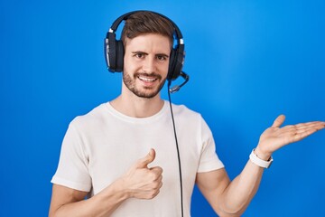 Poster - Hispanic man with beard listening to music wearing headphones showing palm hand and doing ok gesture with thumbs up, smiling happy and cheerful