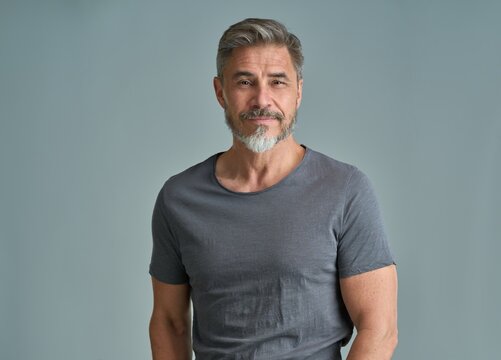 Fototapete -  - Portrait of happy casual older bearded man with gray hair smiling, Mid adult, mature age guy standing, isolated on gray background.