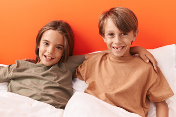 Sticker - Adorable boys hugging each other sitting on sofa at bedroom