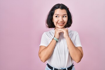 Sticker - Young hispanic woman wearing casual white t shirt over pink background laughing nervous and excited with hands on chin looking to the side