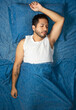 © Narayan - young latin man sleeping blue color bed, rest concept