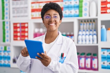 Poster - African american woman pharmacist using touchpad working at pharmacy