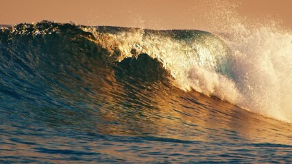 Wall Mural - Ocean wave breaks on the shore at sunset in the Maldives