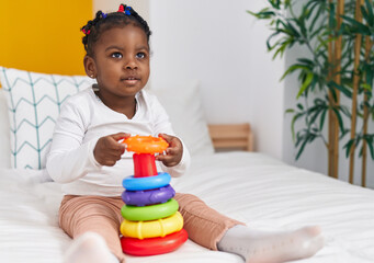 Wall Mural - African american girl playing with hoops game sitting on bed at bedroom